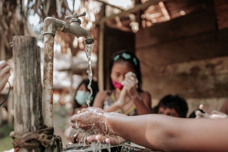 Hands being washed under a stream of clean water